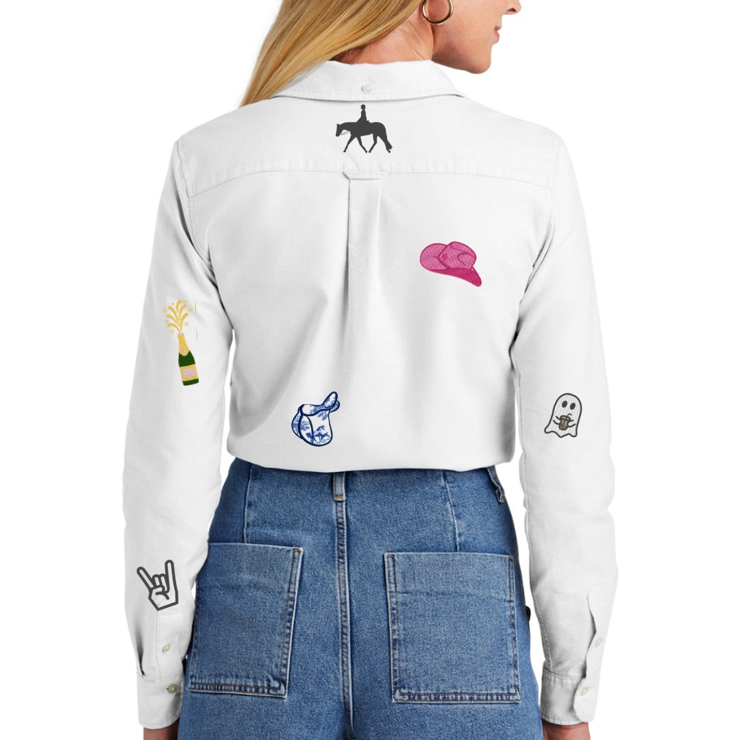 White shirt with colorful embroidered designs worn by a person, on a white background