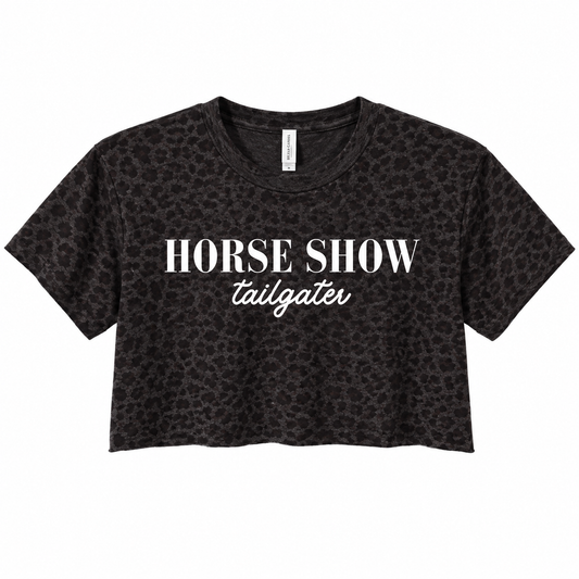 A black cropped t-shirt with a subtle leopard print pattern, featuring the text 'HORSE SHOW' in a bold serif font and 'tailgater' in a white cursive script, displayed on a solid white background.