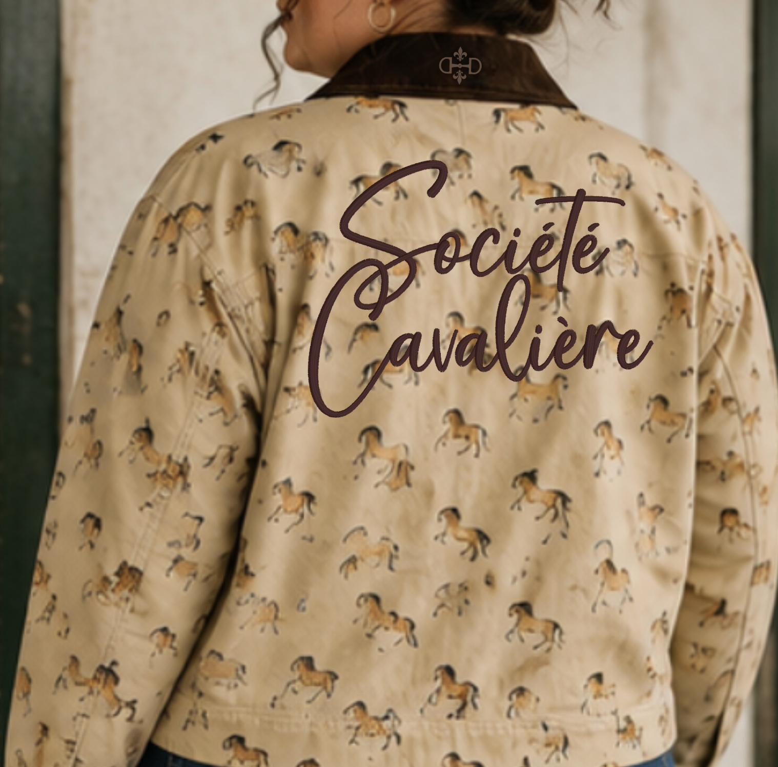 A person shown from the back wearing a beige jacket with an allover horse print and a dark brown collar. The back of the jacket features the embroidered words 'Société Cavaliere' in dark brown script, and a small crest logo is visible near the collar.